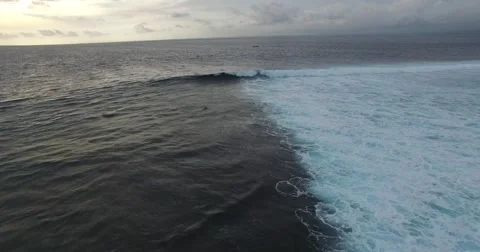 AERIAL SHOT OF SURFER FALLING INTO WAVES IN BALI AT SUNSET Stock Footage 59866065