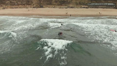 Aerial shot surfing instructor push novice surfer to ocean wave at surf lesson Stock-Footage 108858110