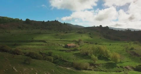 Aerial shot tilting down on a small farmhouse in green fields Stock Footage 77058497