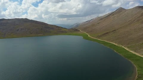 Aerial shot tilting down toward the deep blue waters of an alpine Lake 스톡 동영상 344567553