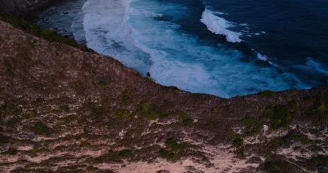 Aerial shot of a tiny path going down steep rocky cliff, dry bushes around Stock Footage 99729917