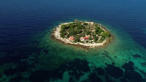 Aerial shot of tiny private island with house, pristine coastline Stock Footage 318925623