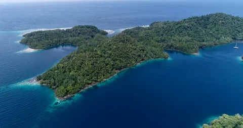 Aerial shot of tiny sailing boat along tropical island with shallow reef Stock-Footage 100322157