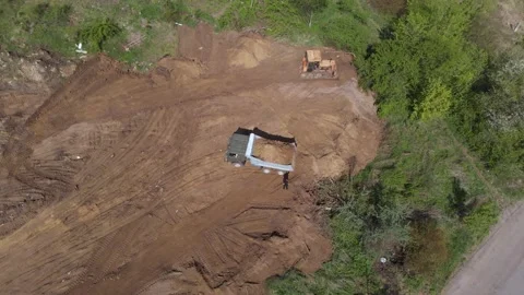 Aerial shot of tipper unloading ground on further construction site. Stock Footage 130220699