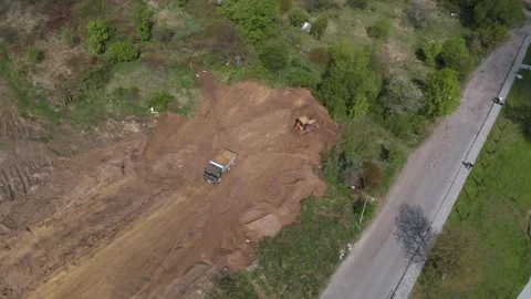 Aerial shot of tipper unloading ground on further construction site. Stock Footage 130222848