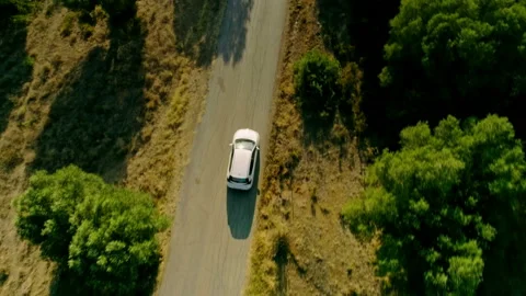 Aerial shot top view white big SUV car driving down country asphalt road at Stock Footage