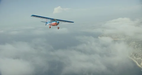 Aerial shot tracking forward in the air toward pilots in small plane, day Video stock 104472934