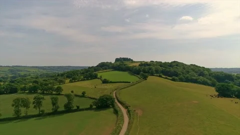 Aerial shot tracking forward over fields and hills in East Devon Stock Footage 138835643