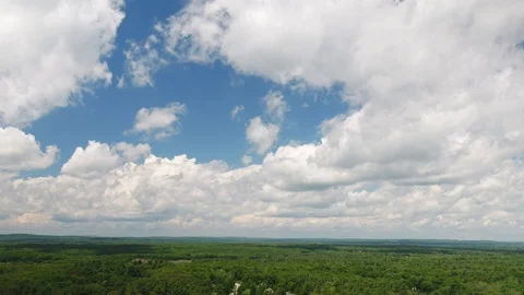 Aerial shot tracking sideways with puffy cumulus clouds above Stock Footage 115506341