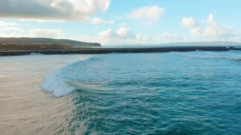 Aerial shot tracking a wave breaking in towards the beach Stock Footage 99071041