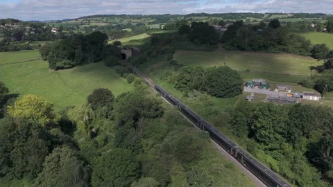 Aerial shot of train entering Box tunnel, in lush Wiltshire countryside on a Stock Footage 337872673