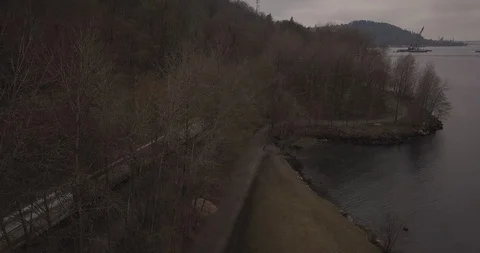 Aerial shot of a train passing by at a provincial park in Burnaby, BC, Canada Stock Footage 89984359