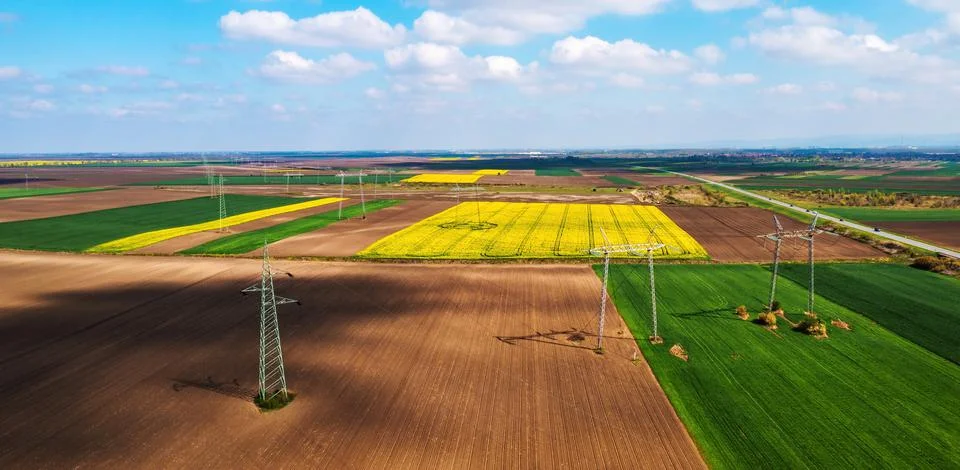 Aerial shot of transmission towers electricity pylons with power lines in cul Stock Photos