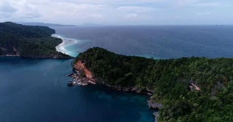 Aerial shot of tropical island with patch of red rocks and turquoise water Vídeos de archivo 100276139