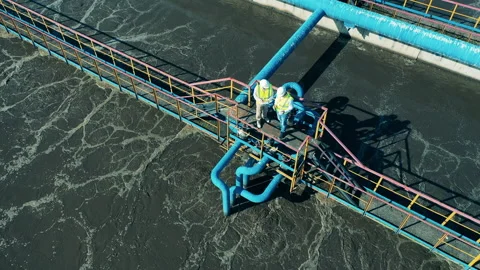 Aerial shot of two male wastewater operators at a wastewater treatment facility Stock Footage