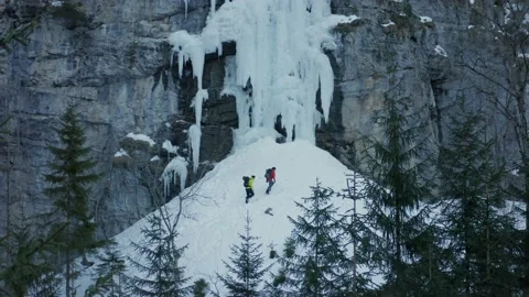 Aerial shot of two men walking to climb an icefall in winter, Alps, Switzerland Stock Footage 239568081