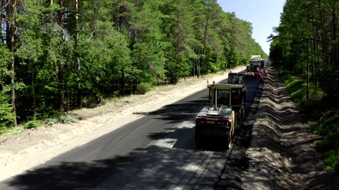 Aerial Shot Of Two Road Rollers Driving On A Tarmac Road In A Forest Video stock 142003822