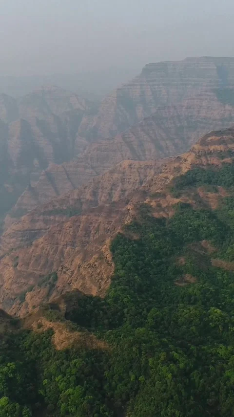 Aerial shot of valleys between steep rocky hills, green vegetation on top Stock Footage 226870202
