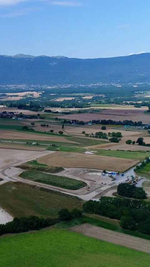 Aerial shot of various fields and villages with mountain background Video stock 225552980