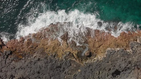 Aerial shot. Vertical plan camera pull down. the waves are splashing blue and Stock Footage 104164445