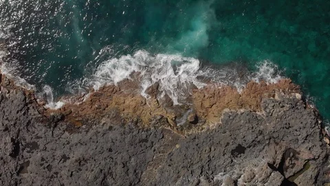 Aerial shot. Vertical plan down. The blue and turquoise ocean and sea foaming Stock Footage 103850217