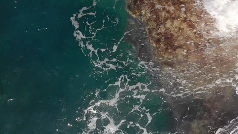 Aerial shot. Vertical plan down. the waves are splashing blue and turquoise in Video stock 104029727