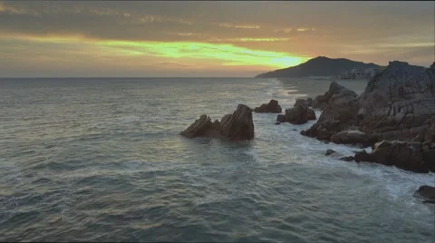 Aerial shot of waves hitting cliffs and rocks on a sandy beach in Cabo, Mexico Vidéo 67583186