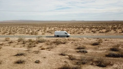 Aerial Shot of White Van and Cars on Road Surrounded by Desert Stock Footage