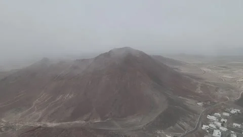 Aerial shot within clouds of a red volcano in Lanzarote at the Canary Islands Stock Footage 250243337