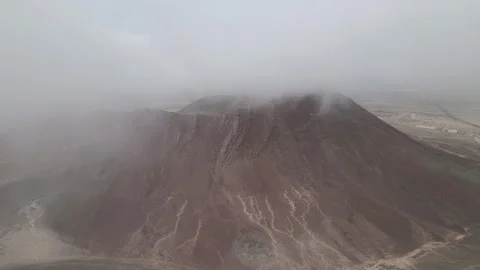 Aerial shot within clouds of a red volcano in Lanzarote at the Canary Islands Stock Footage 250243382