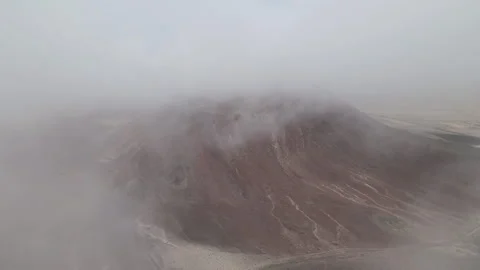 Aerial shot within clouds of a red volcano in Lanzarote at the Canary Islands Stock Footage 250243443
