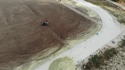 Aerial shot of workers assembling irrigation system on school football stadium. Stock Footage 123435580