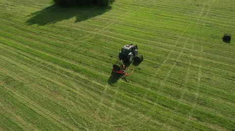Aerial Shot of Working Tractor with Bale Lifter on Agricultural Field at Bright  Stock Footage 65249234