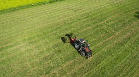 Aerial Shot of Working Tractor with Bale Lifter on Agricultural Field at Bright  Stock Footage 65254175