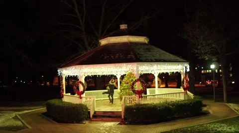 Aerial shot of young couple embracing and twirling in a gazebo during Christmas Stock Footage 59191953