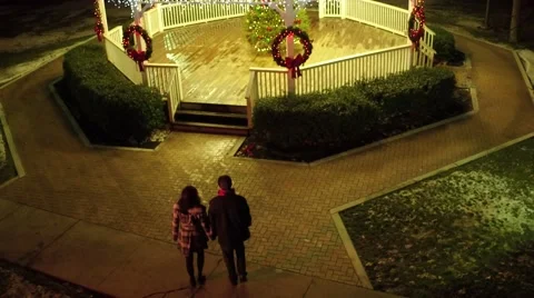Aerial shot of young couple walking into gazebo at Christmas Stock Footage 59188097