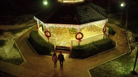 Aerial shot of young couple walking into gazebo during the Christmas holiday Stock Footage 59188155