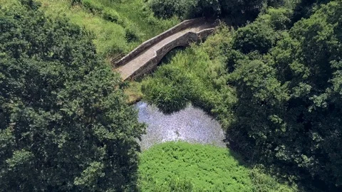 Aerial side and top view, up move. Drone fly over old small sandstone bridge Video stock 93487933