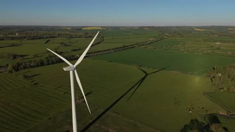 Aerial side flyby of rotating wind turbine above green countryside Stock-Footage 333935088