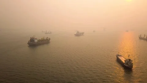 Aerial side scrolling shot of hazy sunrise vessel anchorage , Singapore Stock Footage 118602664