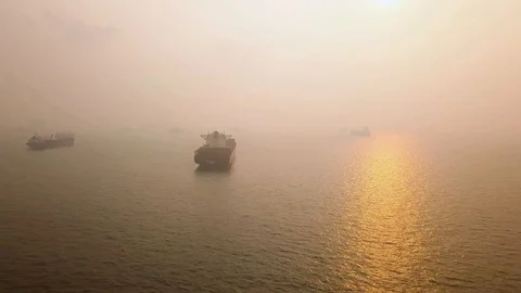 Aerial side scrolling shot of hazy sunrise vessel anchorage , Singapore Stock Footage 118602966