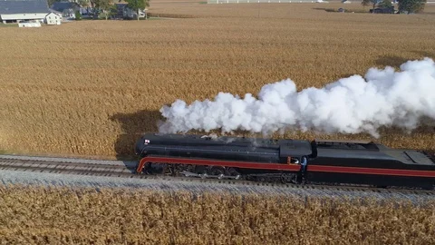 Aerial side by side view of a steam engine blowing steam and smoke Stock Footage 124435643