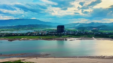 Aerial side tracking shot over river and village under mountain range 4K Vídeo Stock 340747521