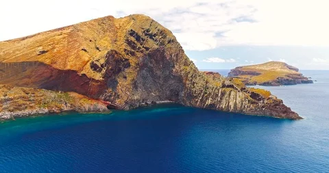 Aerial side view of beautiful cliffs and ocean at Sao Lourenco peninsula Stock Footage 106671559