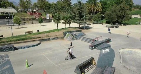 AERIAL SIDE VIEW OF BIKER DOING TRICKS IN SKATE PARK 4k Stock Footage 102379150