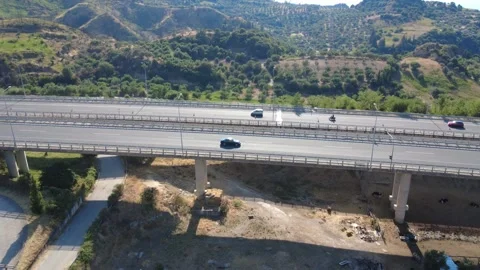 Aerial side view of highway overpass bridge with pillars and traffic Stock Footage 343962125