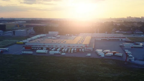 Aerial side view of logistics park with warehouse, loading hub with semi trucks Video stock 125495406