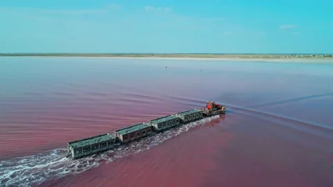 Aerial side view of an old train rides on the railway laid in the water through Stock Footage 231602614