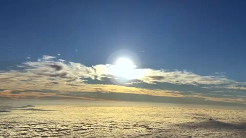 An Aerial Side View of a Sunrise Through a Layer of Ethereal Clouds Bathed by Stock Footage 319052386