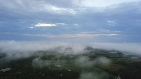AERIAL: side ways drop through the blanket of clouds revealing the Stock Footage 99075617